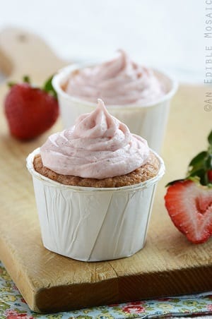strawberry cupcake in a white cupcake liner with strawberry frosting on top 