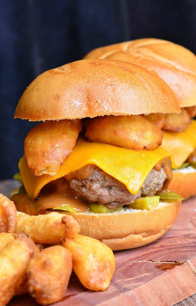 Onion Ring BBQ Cheeseburger, 2 cheeseburger on a bun with pickles under it and onion rings on top 