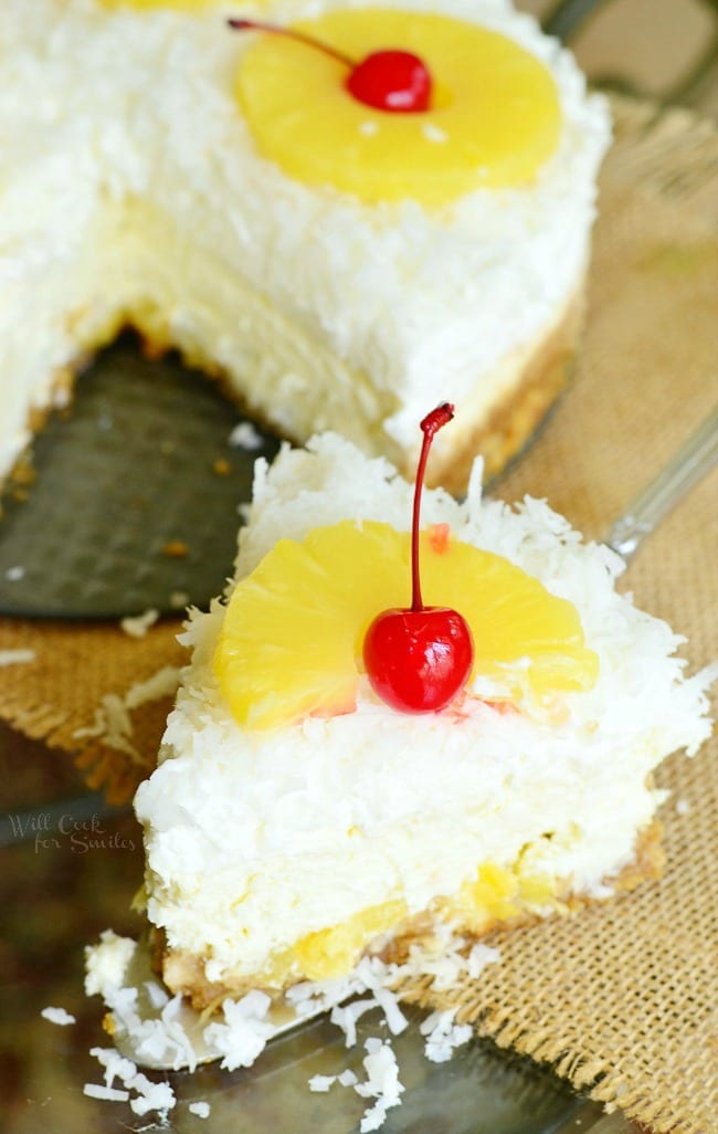 Top view of pina Colada Cheesecake with coconut, cherry, and pineapple 