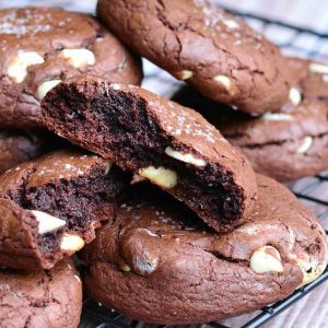 close up view of view from above of salted chocolate white chocolate chip cookies on a wire cooling rack on top of a wooden table and top cookie broken into 2