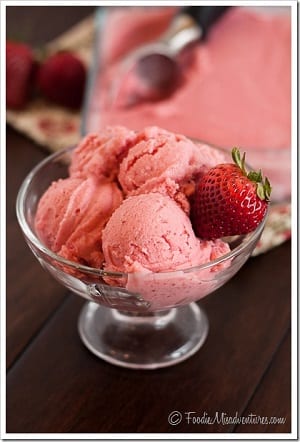 strawberry sherbet in a bowl with a strawberry as garnish 