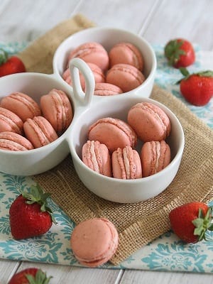 Strawberry rhubarb macarons in 3 white serving bowls