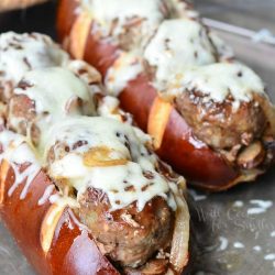 2 bacon buffalo meatball subs on a baking pan viewed close up