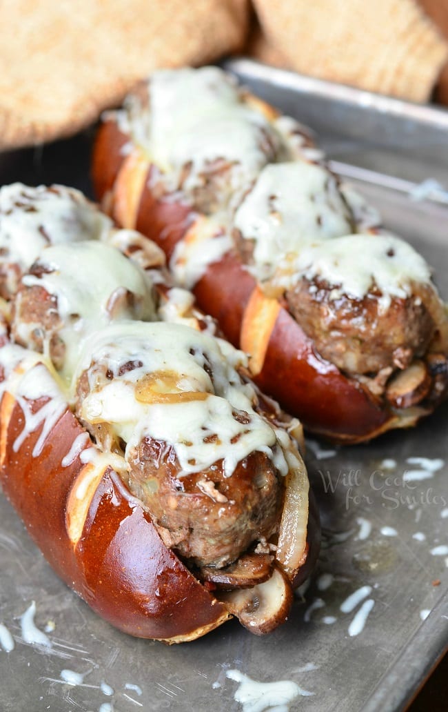 For this Bacon Buffalo Meatball Sub, juicy meatballs are lined up in a soft pretzel sub roll, baked with sauteed onions, mushrooms and bacon and topped with lots of mozzarella cheese.