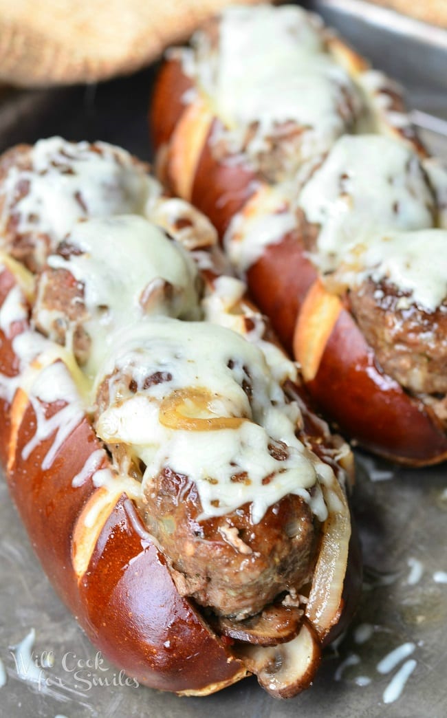 For this Bacon Buffalo Meatball Sub, juicy meatballs are lined up in a soft pretzel sub roll, baked with sauteed onions, mushrooms and bacon and topped with lots of mozzarella cheese.