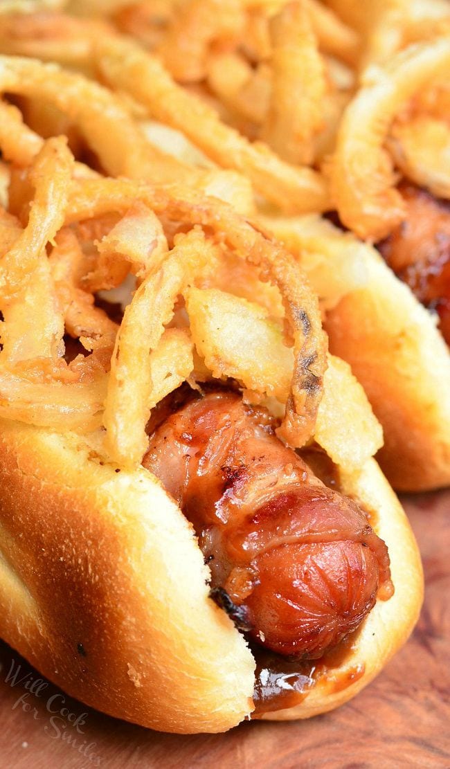 hot dog recipe on a bon with fried onions on a wood cutting board 