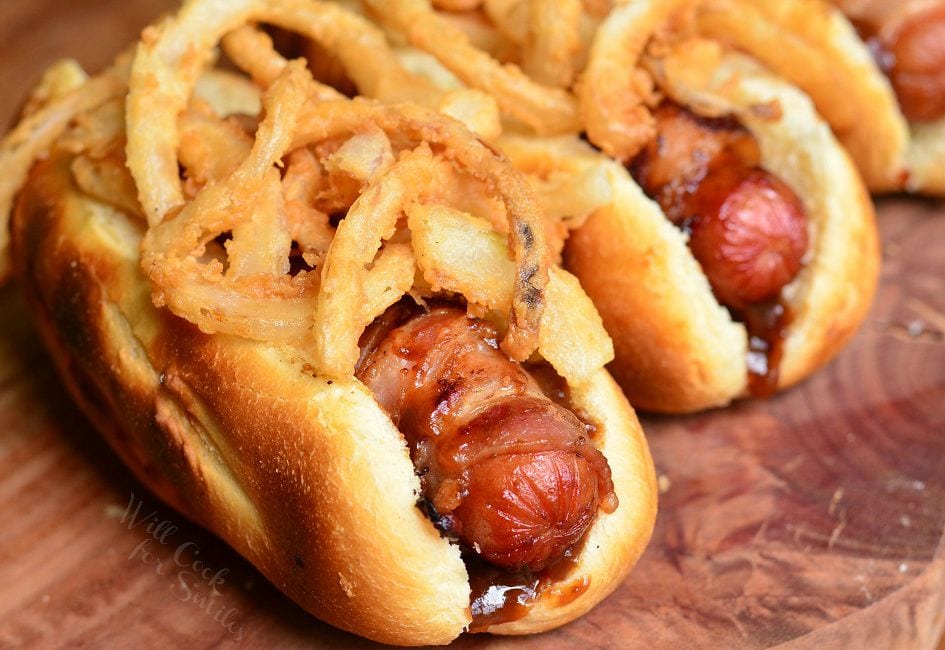 BBQ Hot Dogs in a bun on a wood cutting board 