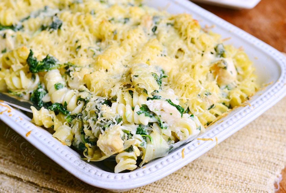 Chicken Spinach and Artichoke Pasta served in a white casserole dish.