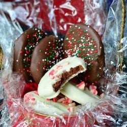 pile of chocolate covered peppermint crunchy cookies filling up a gift bucket with plastic wraping and filler