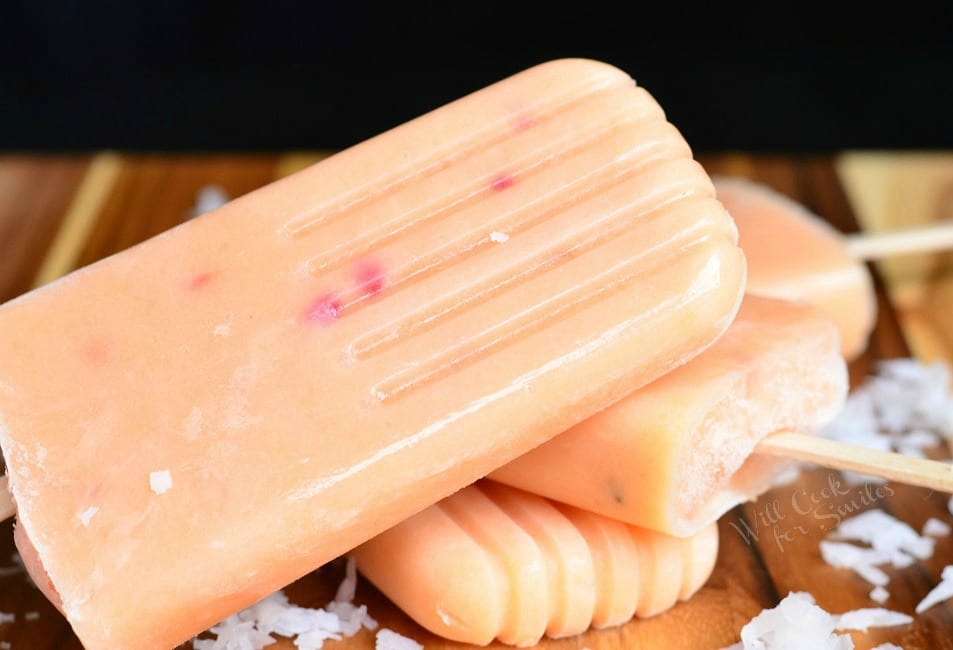 Coconut and Peach Creamy Fruit Ice Pops stacked up on a cutting board 