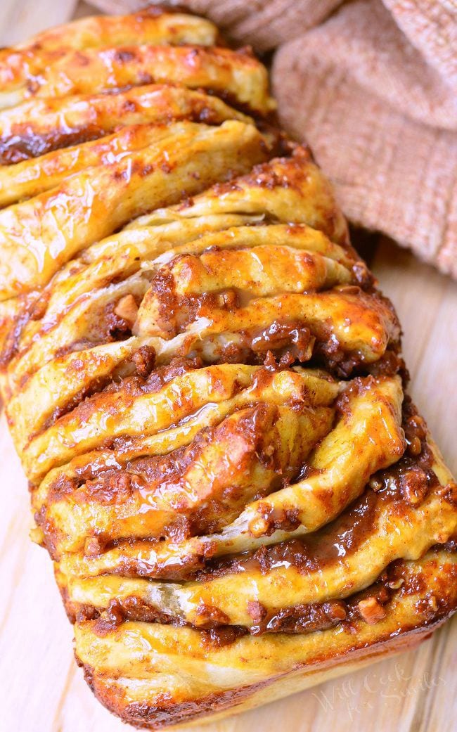 Top view of the Easy Caramel Pumpkin Pull Apart Bread. Each layer is slathered in pumpkin, caramel, and pecans. There is a caramel sauce drizzled on top as well.