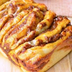 close up view of easy pumpkin caramel pull apart bread on a wooden table with a brown cloth in the background