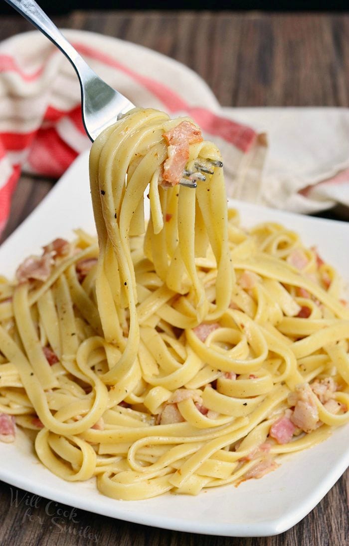 Fettuccine with Bourbon Bacon Sauce on a plate lifting some up with a fork 