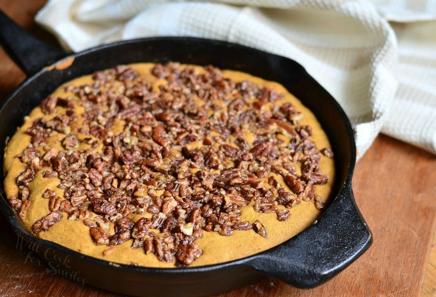 Giant Pumpkin Skillet Cookie in a cast iron pan with pecans on top 