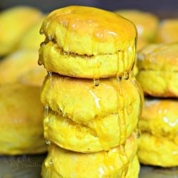 stacks of honey pumpkin biscuits on a metal sheet tray on a wooden table as viewed close up