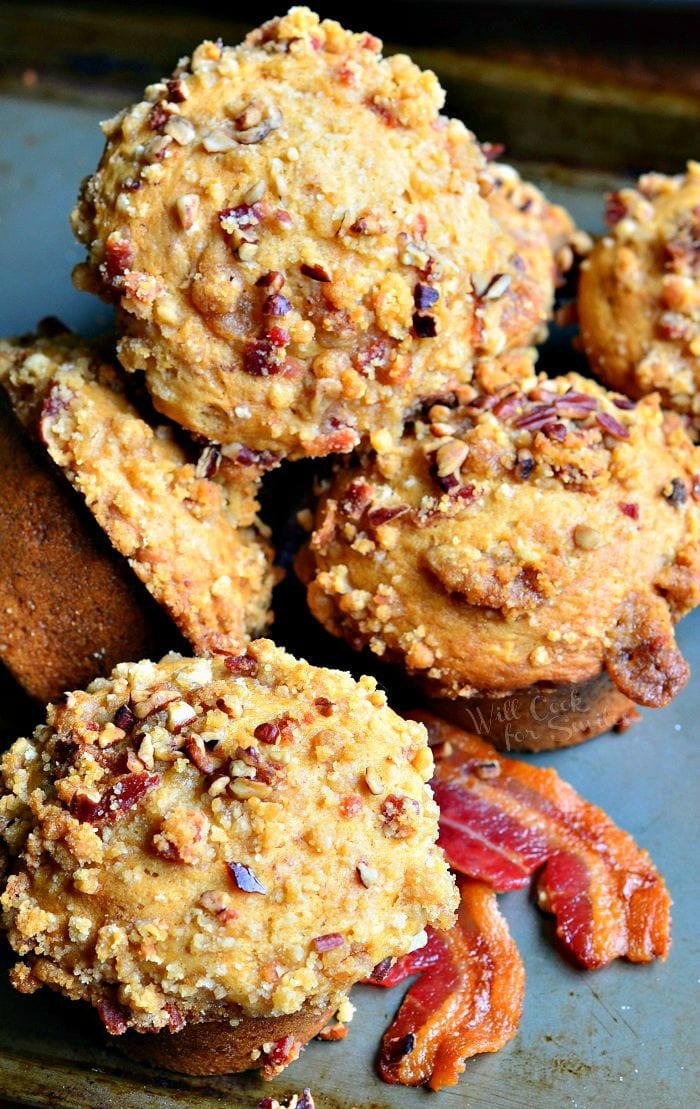 Maple Bacon Streusel Muffins stacked up with bacon around it on a baking dish 