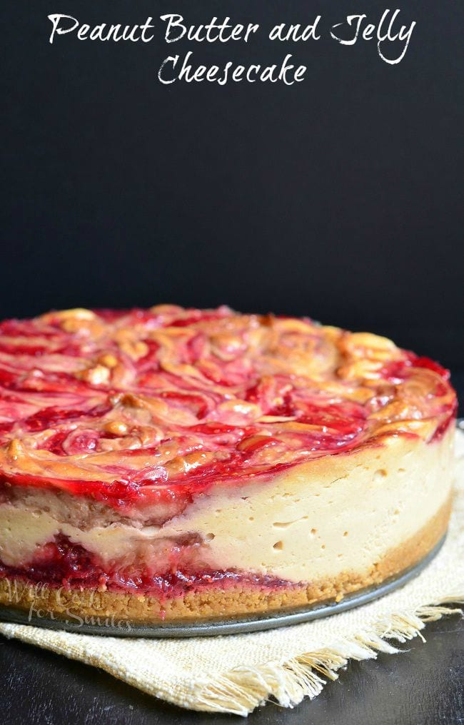picture of whole peanut butter and jelly cheesecake on a white cloth while all sit on a black table