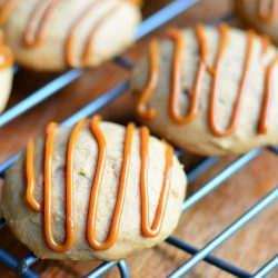 pumpkin dulce de leche nutella cookies on a metal cooling rack on top of a wooden table as viewed close up