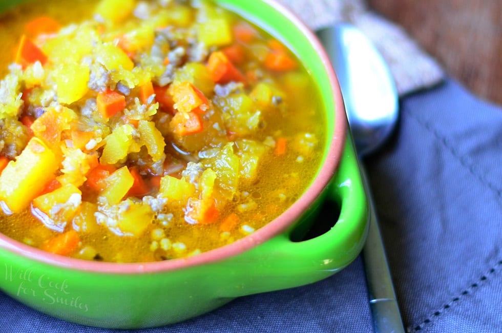 Pumpkin Sausage Soup in a green bowl on table 