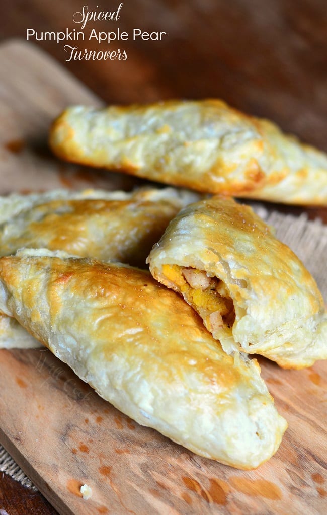 4 spiced pumpkin apple pear turnovers on a wooden cutting board