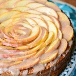 picture of a whole cinnamon glazed apple cake on a white cake presenter as shown from above