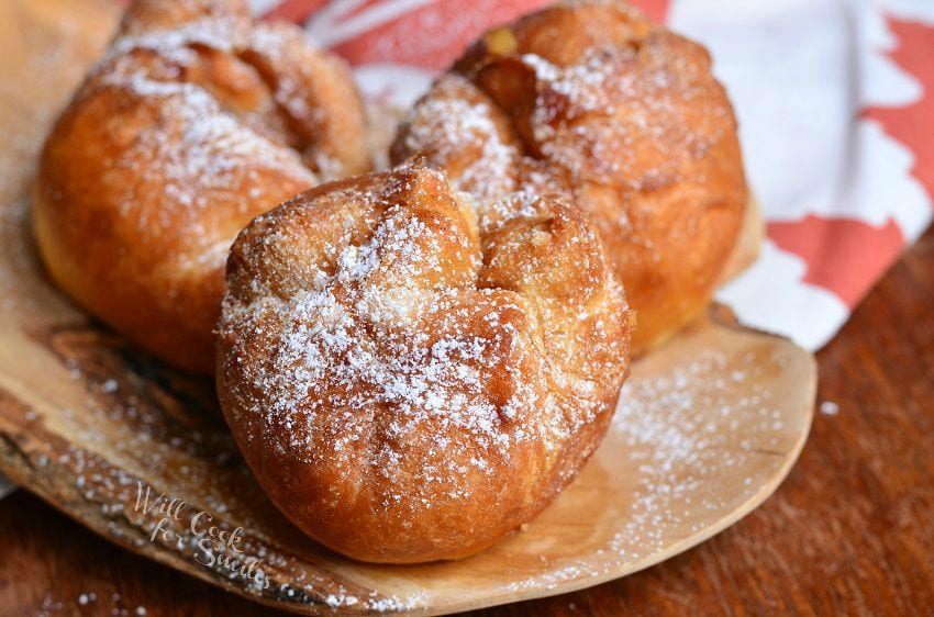 three Apple Pie Doughnuts on a wood plate on a wood table 