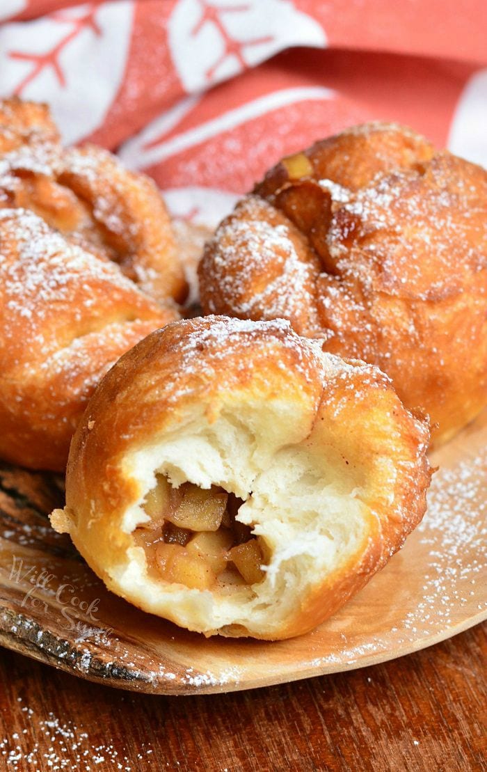 Apple Pie Doughnuts on a brown plate with one having a bite taken out of it 