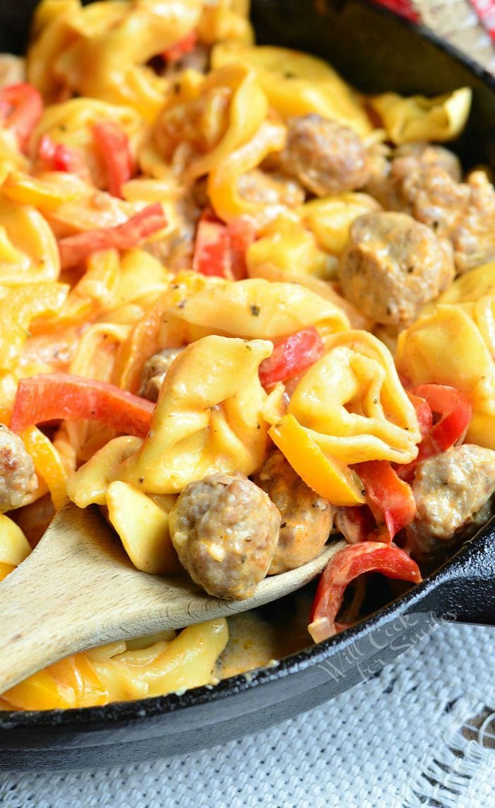 Sausage Peppers and Onion Tortellini Skillet in a pan with a wooden spoon 