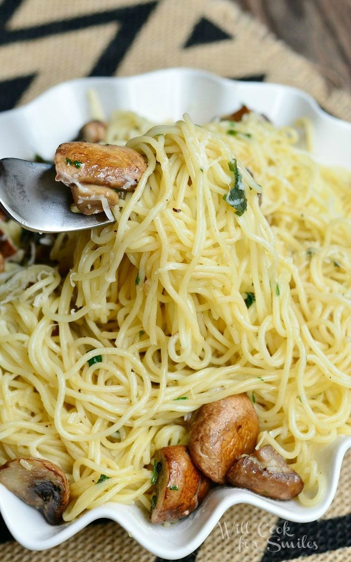 Truffle Pasta and Mushrooms in a white serving bowl with a fork lifting a some out 