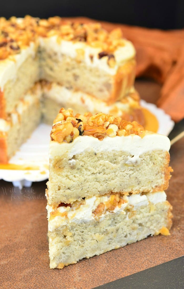 Caramel Banana Nut Cake slice on a table with the rest of the cake in the background