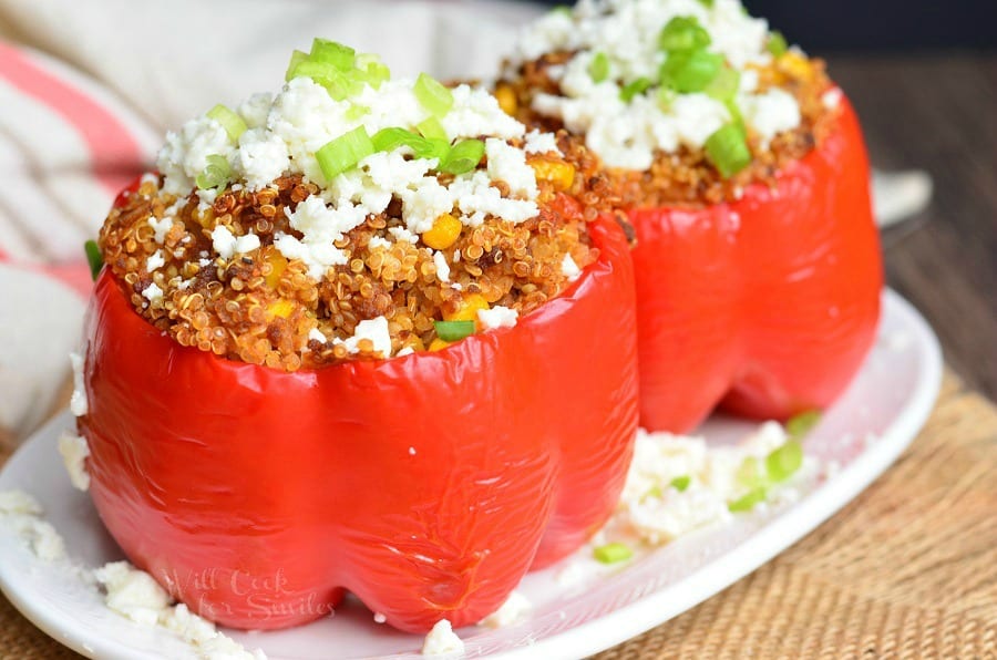 two red stuffed peppers with Chorizo and Quinoa inside on a plate 