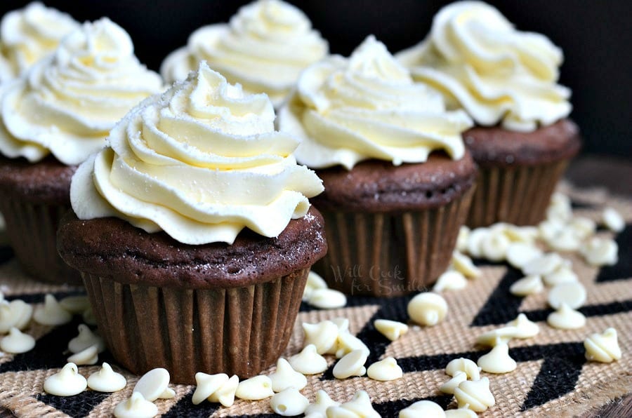  Double Chocolate Cupcakes with cream cheese cupcakes on a table with white chocolate chips around the it 