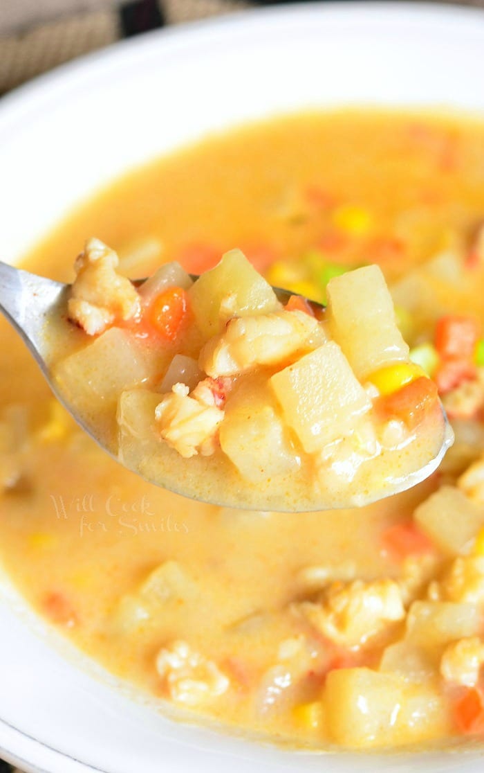 Lobster, Potato and Corn Chowder in a bowl with a spoon scooping some out 