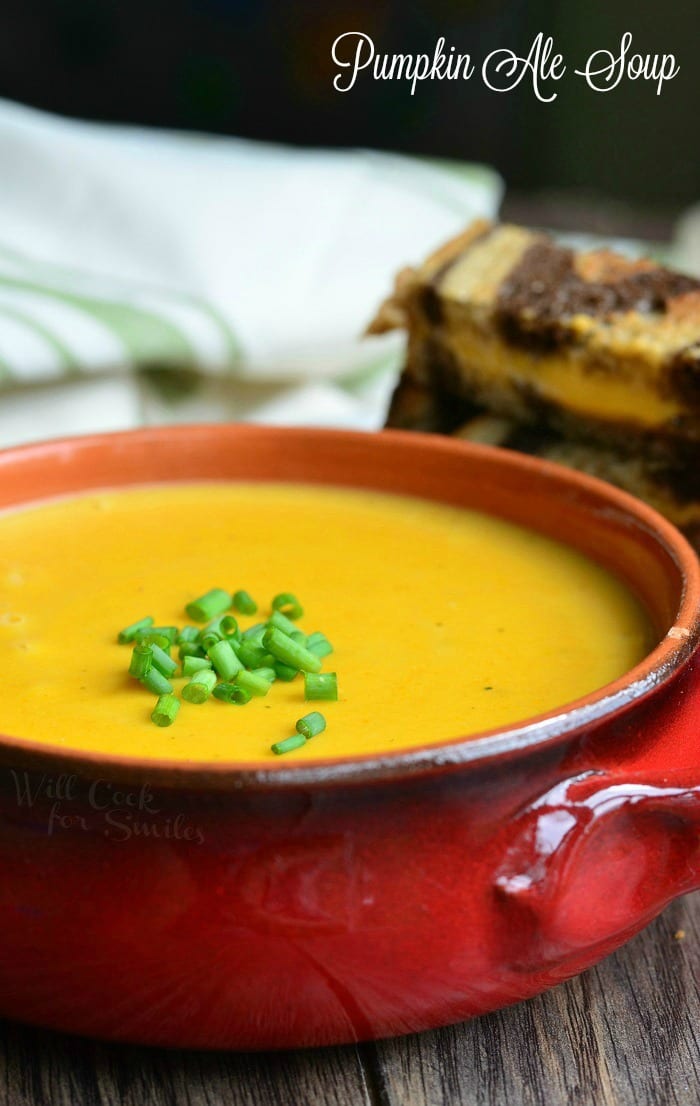 Pumpkin Ale Soup in a orange soup bowl with chives on top as a garnish 