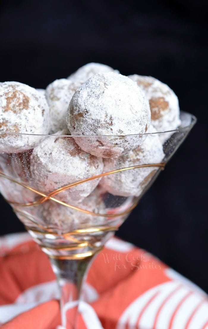 Pumpkin Spice Rum Balls with powder sugar on the outside of them in a champagne glass 