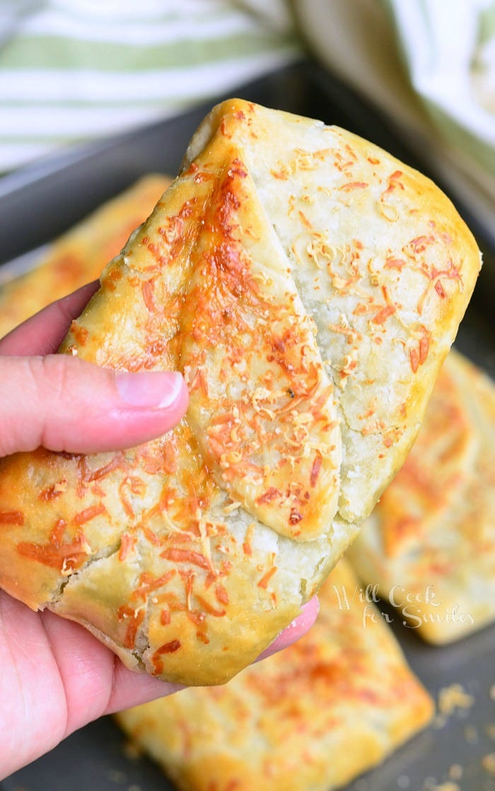 Holding a spinach Artichoke Hand Pies 