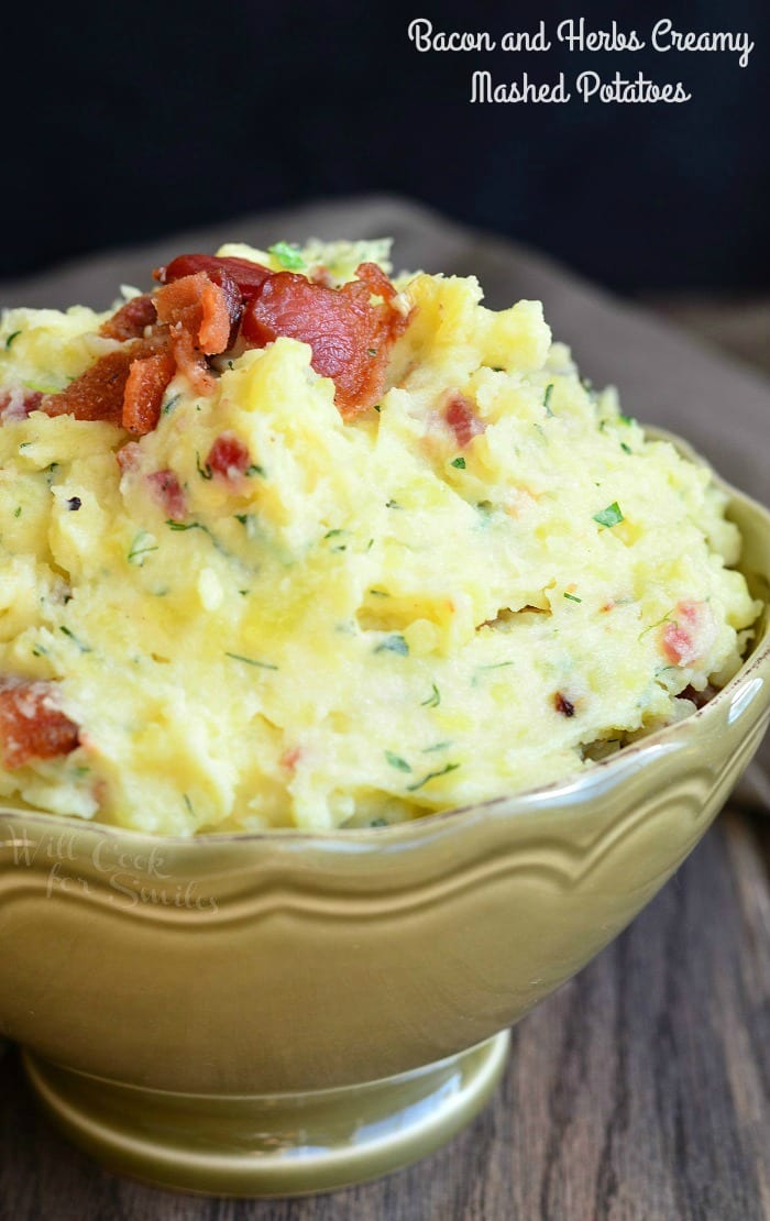 Mashed Potatoes with bacon and herbs mixed in and bacon on top  in a bowl 