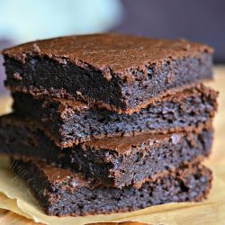 stack of 4 pumpkin brownies on a wax paper as viewed from the front