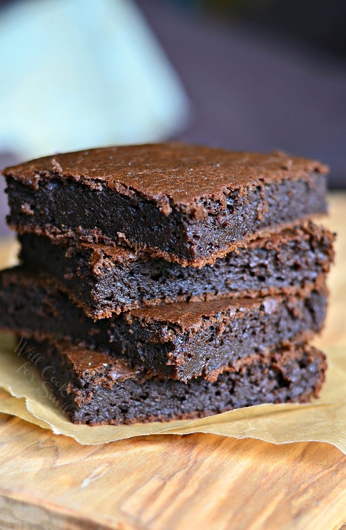 Pumpkin Brownies stacked on top of each other on a parchment paper 