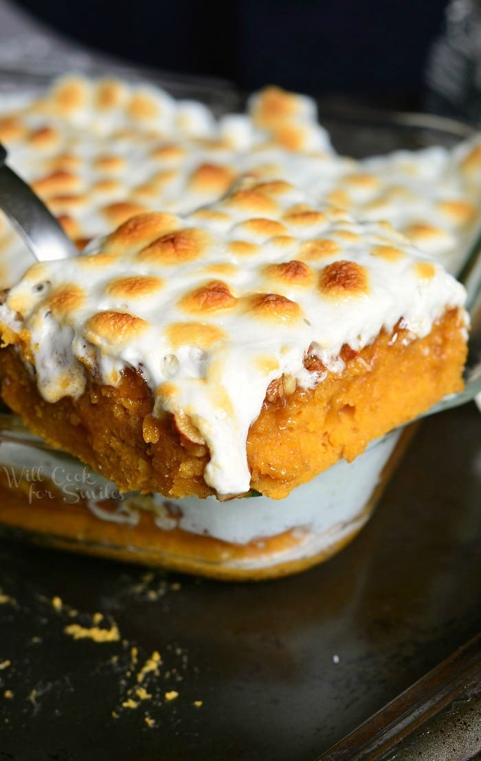 Sweet Potato Casserole Cake with melted marshmallows on top being lifted out by a spatula 