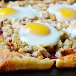 Close up view of Thanksgiving leftover tart featuring turkey stuffing, egg and cranberry