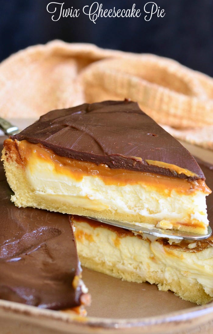 Twix Cheesecake Pie being lifted out of pie pan with a pie spatula 