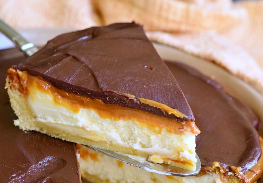 Twix Cheesecake Pie being lifted out of pie pan with a pie spatula 