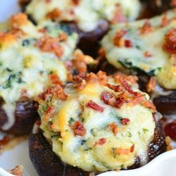 Decorative oval platter filled with bacon spinach and four cheese stuffed mushrooms