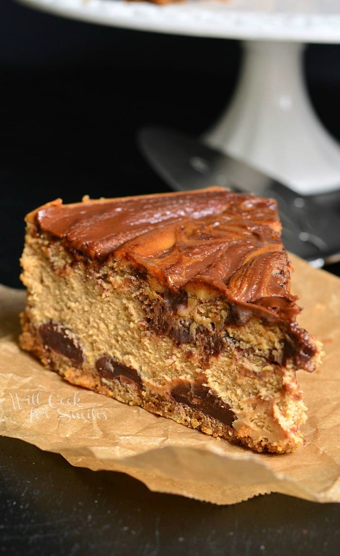 1 slice of gingerbread nutella swirl cheesecake in front of a cake stand with additional cake