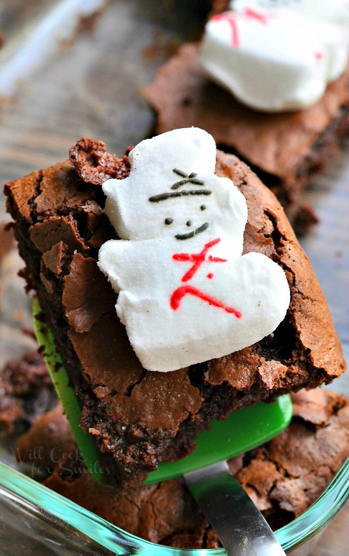 Brownies with snowman marshmallows on top on a green spatula 