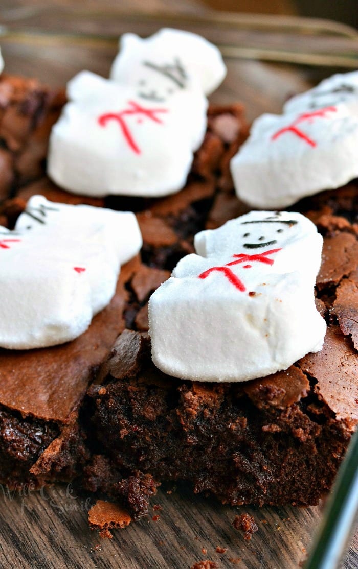 Brownies with snowman marshmallows on top in a clear glass baking pan 