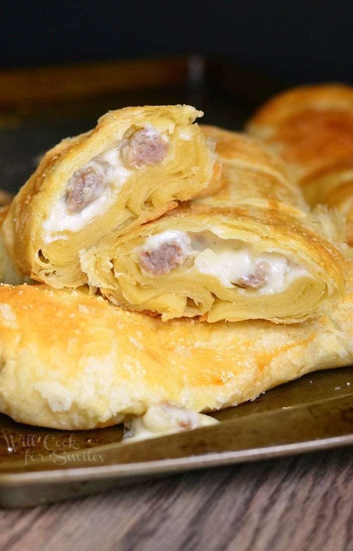 Pastry with sausage gravy and sausage in it on a baking sheet 