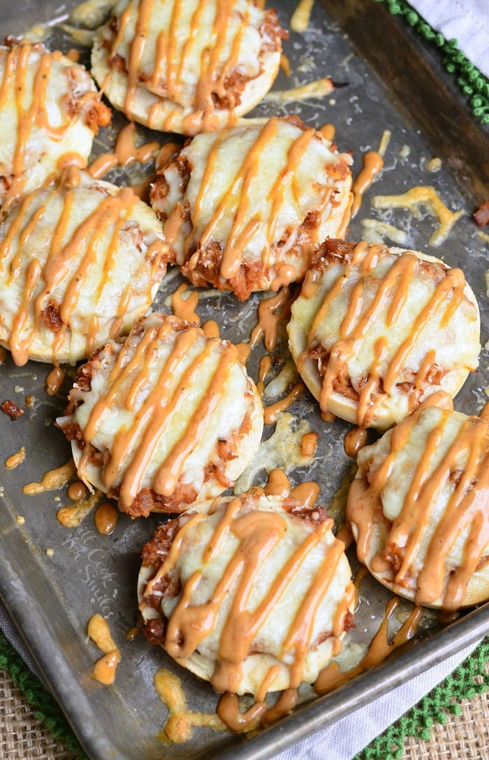 Top view photo bagel with BBQ smoked chicken, Monterrey Jack and Asiago cheeses, and topped with BBQ Ranch dressing on a baking dish 