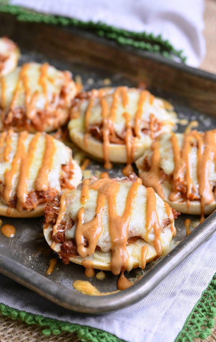 Bagel with BBQ smoked chicken, Monterrey Jack and Asiago cheeses, and topped with BBQ Ranch dressing on a baking dish 